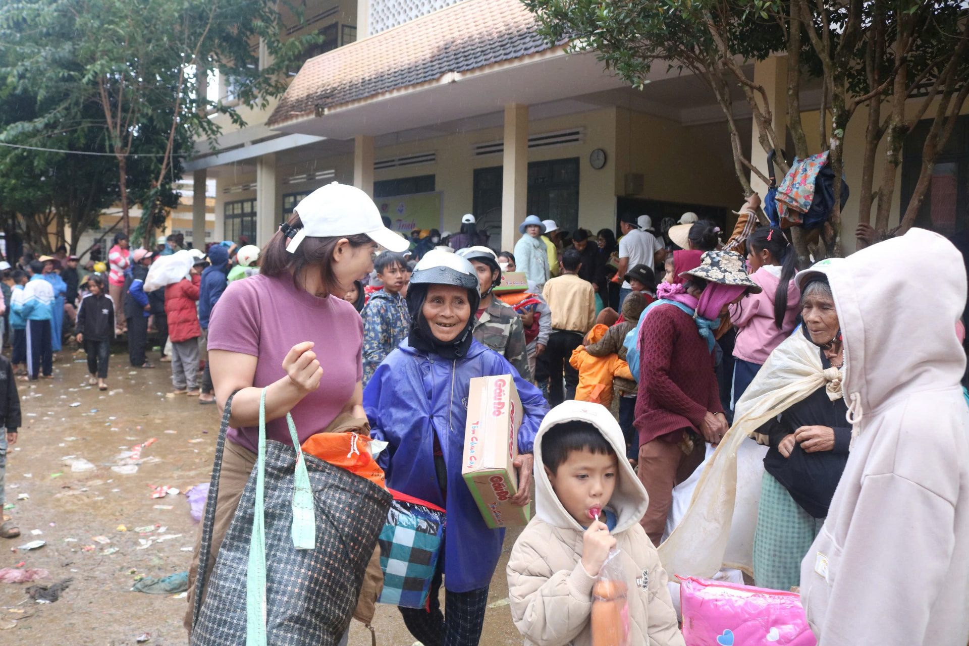 Families leaving the schoolyard with gift bags and food parcels