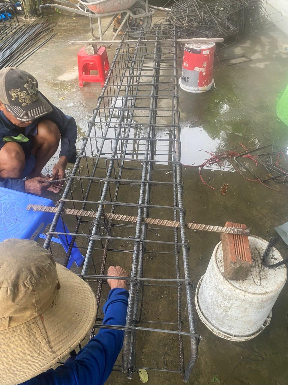 Workers tying steel reinforcement cages by hand