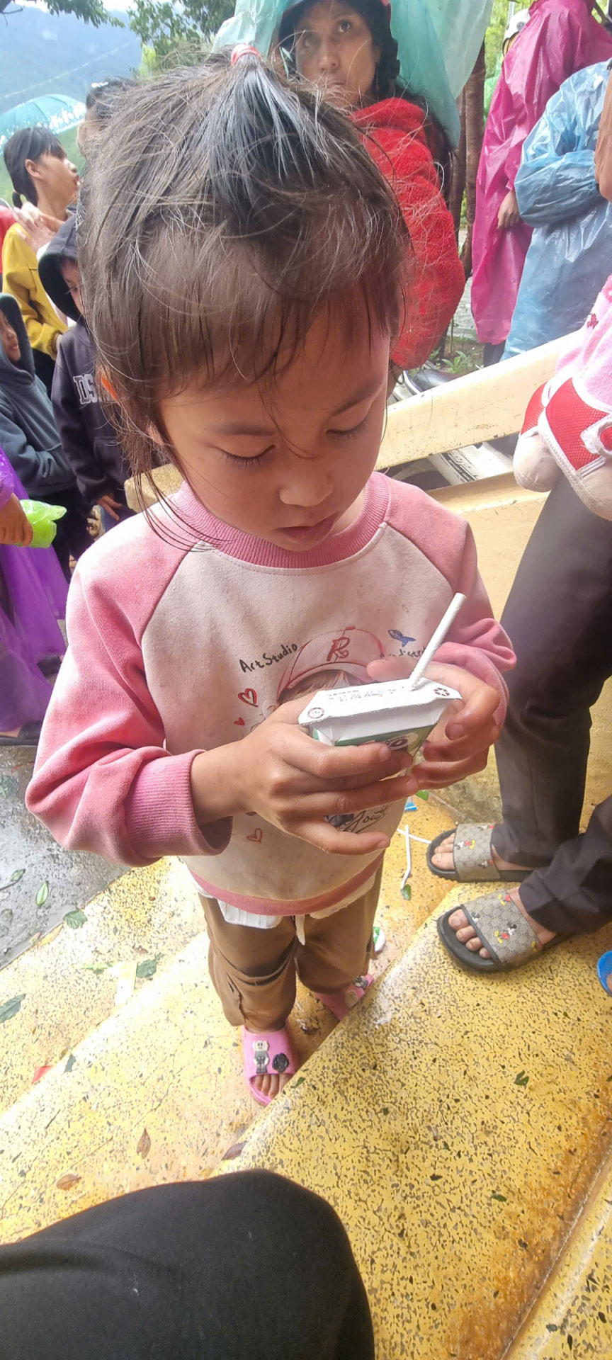 A young girl drinking a carton of milk